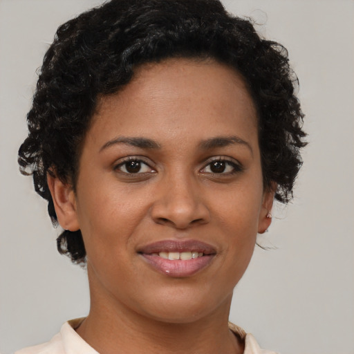 Joyful black young-adult female with short  brown hair and brown eyes