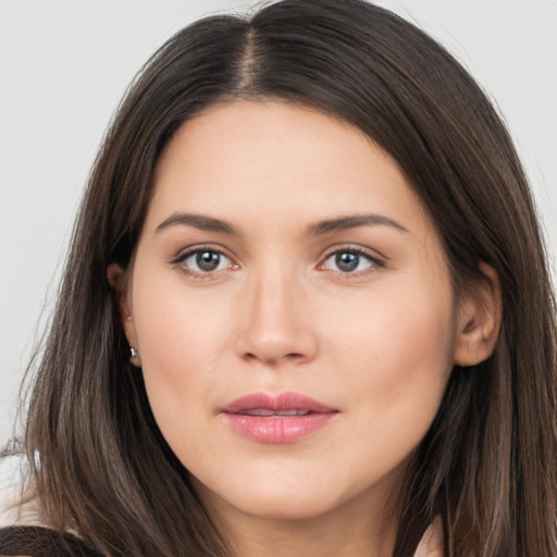 Joyful white young-adult female with long  brown hair and brown eyes