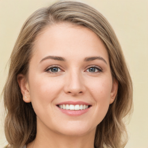 Joyful white young-adult female with long  brown hair and green eyes