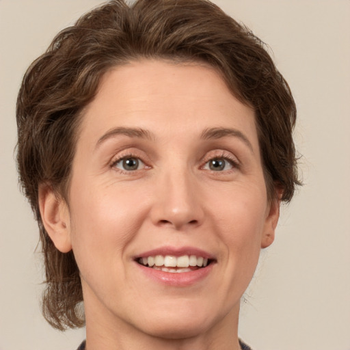 Joyful white young-adult female with medium  brown hair and green eyes