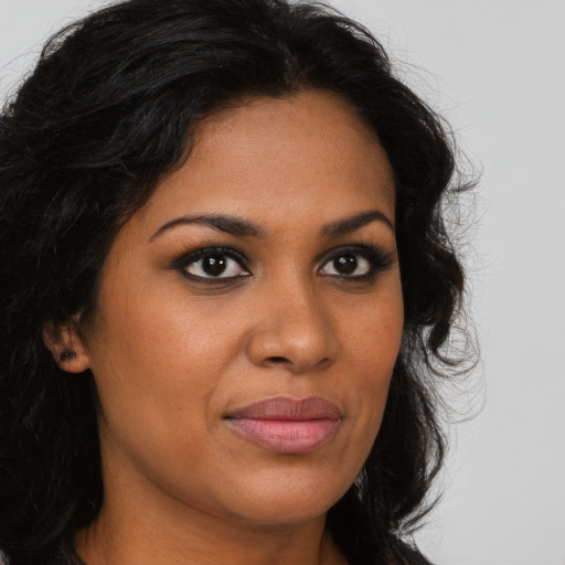 Joyful black young-adult female with long  brown hair and brown eyes