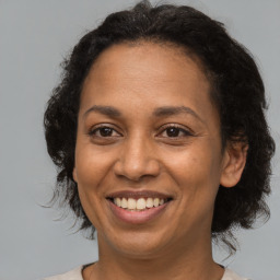 Joyful black adult female with medium  brown hair and brown eyes