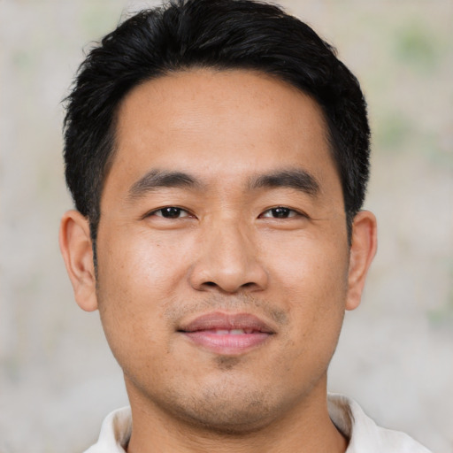 Joyful asian young-adult male with short  black hair and brown eyes