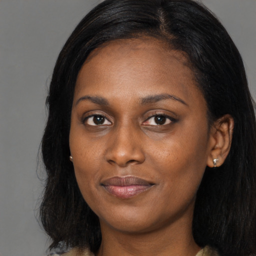 Joyful black young-adult female with long  black hair and brown eyes