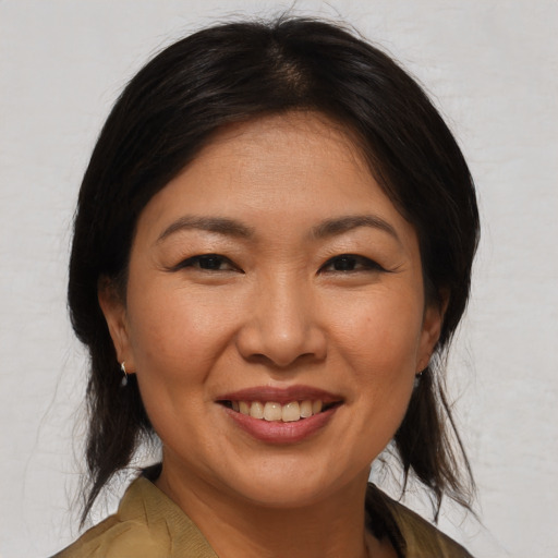Joyful asian adult female with medium  brown hair and brown eyes