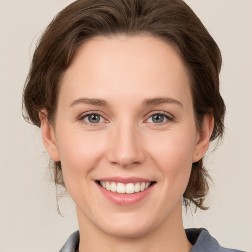 Joyful white young-adult female with medium  brown hair and grey eyes