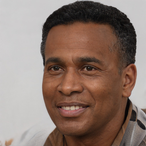 Joyful black adult male with short  black hair and brown eyes