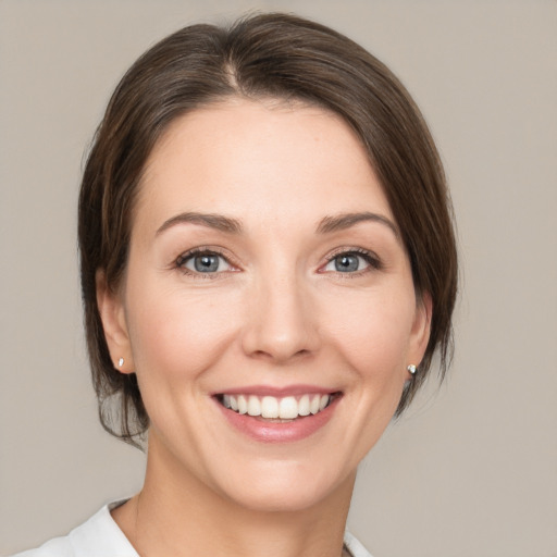 Joyful white young-adult female with medium  brown hair and green eyes