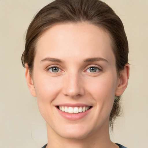 Joyful white young-adult female with short  brown hair and green eyes