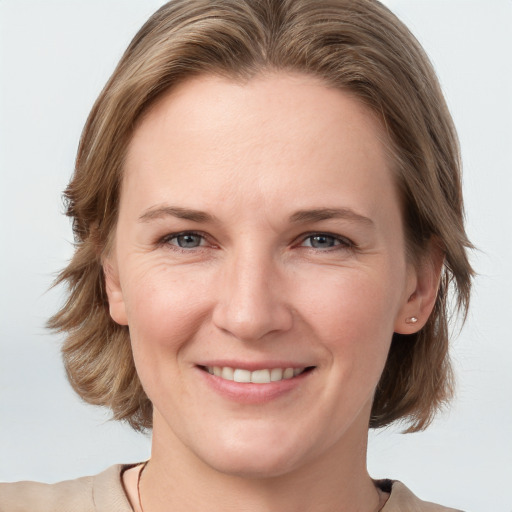 Joyful white adult female with medium  brown hair and grey eyes