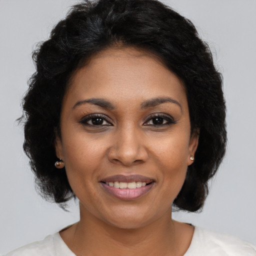 Joyful black young-adult female with medium  brown hair and brown eyes