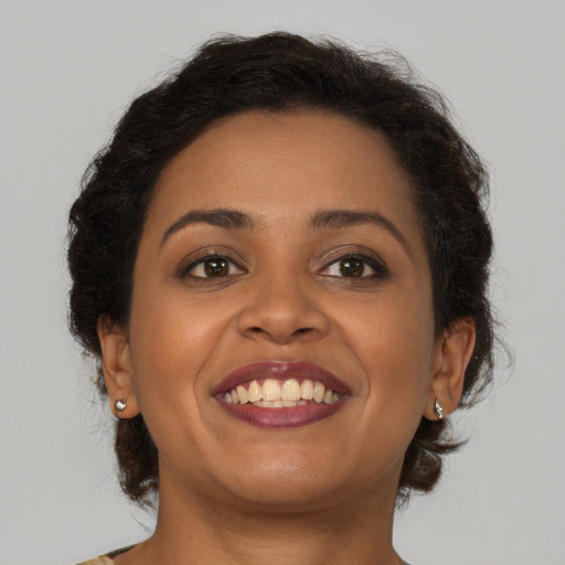 Joyful black young-adult female with medium  brown hair and brown eyes