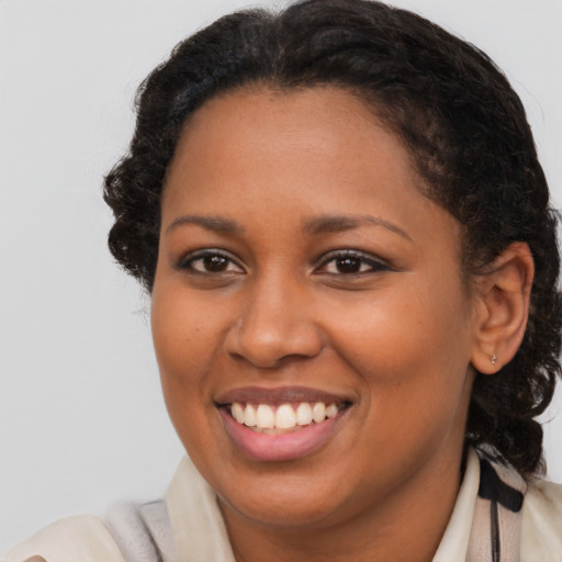 Joyful black young-adult female with medium  brown hair and brown eyes