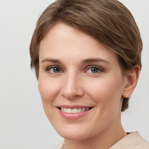 Joyful white young-adult female with short  brown hair and grey eyes