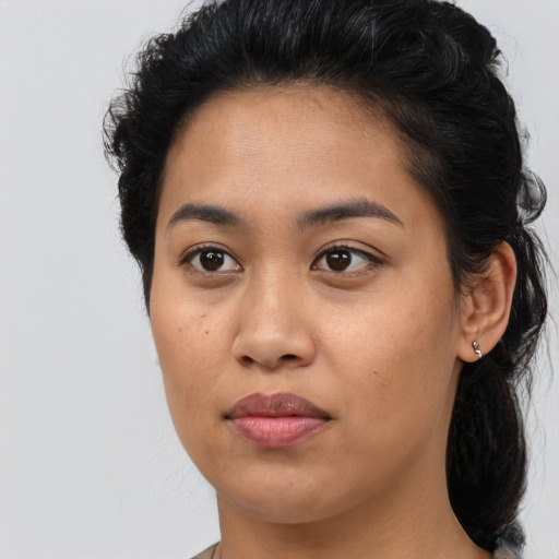 Joyful latino young-adult female with medium  brown hair and brown eyes