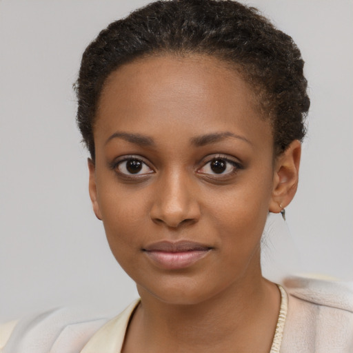 Joyful black young-adult female with short  brown hair and brown eyes