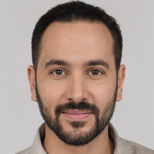 Joyful white young-adult male with short  black hair and brown eyes