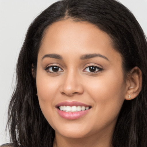 Joyful latino young-adult female with long  brown hair and brown eyes