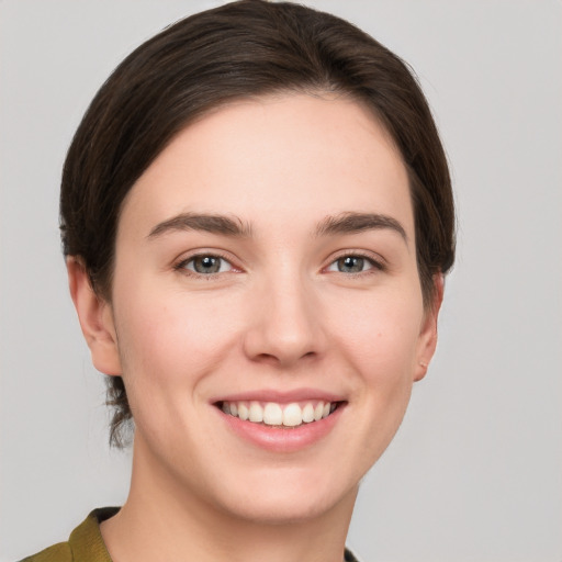 Joyful white young-adult female with short  brown hair and grey eyes