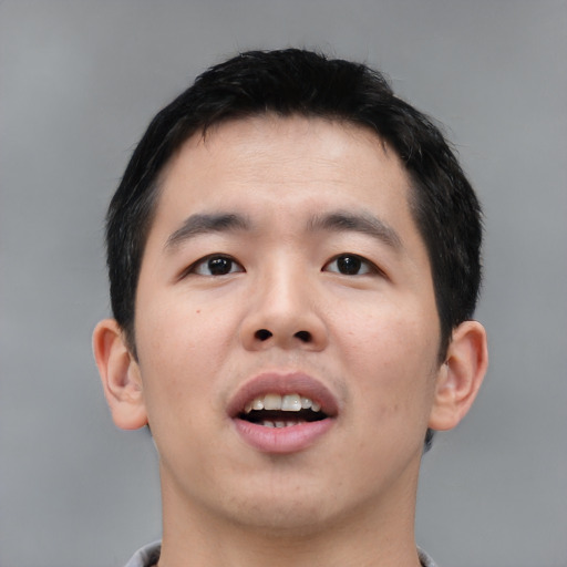 Joyful asian young-adult male with short  black hair and brown eyes