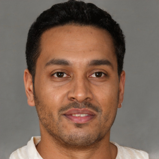 Joyful latino young-adult male with short  brown hair and brown eyes
