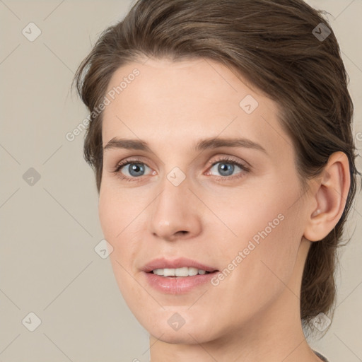 Joyful white young-adult female with medium  brown hair and green eyes