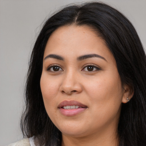 Joyful latino young-adult female with long  black hair and brown eyes