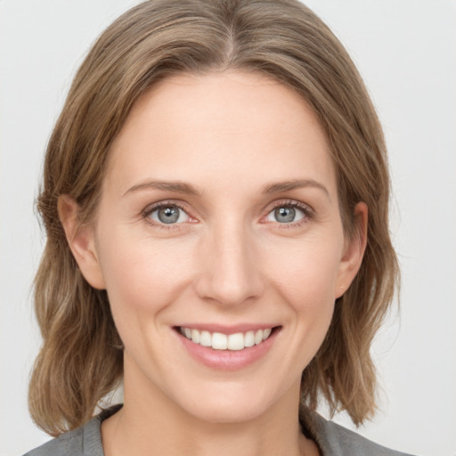 Joyful white young-adult female with medium  brown hair and blue eyes