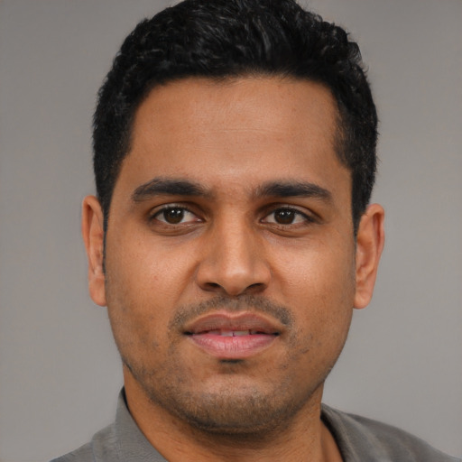 Joyful latino young-adult male with short  black hair and brown eyes