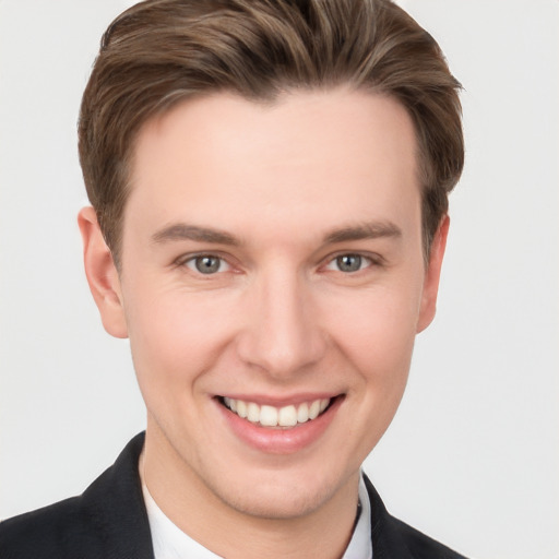 Joyful white young-adult male with short  brown hair and grey eyes