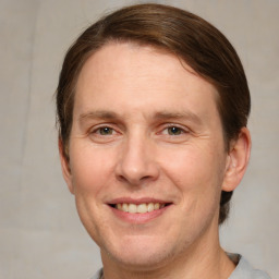 Joyful white adult male with short  brown hair and grey eyes