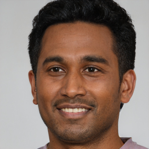 Joyful black young-adult male with short  black hair and brown eyes