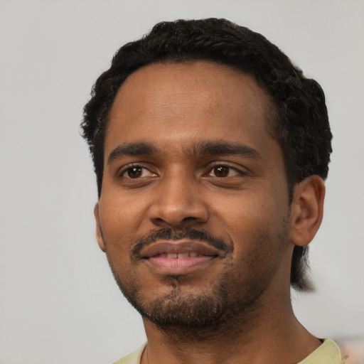 Joyful black young-adult male with short  black hair and brown eyes