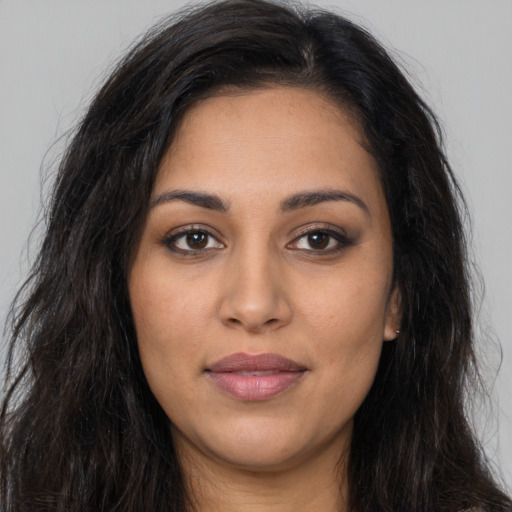 Joyful latino young-adult female with long  brown hair and brown eyes