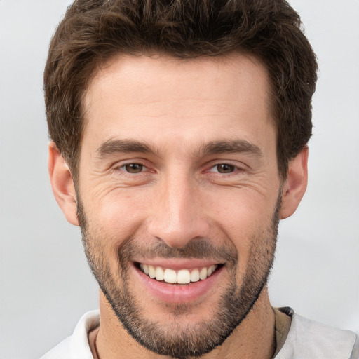 Joyful white young-adult male with short  brown hair and brown eyes