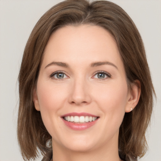 Joyful white young-adult female with medium  brown hair and green eyes