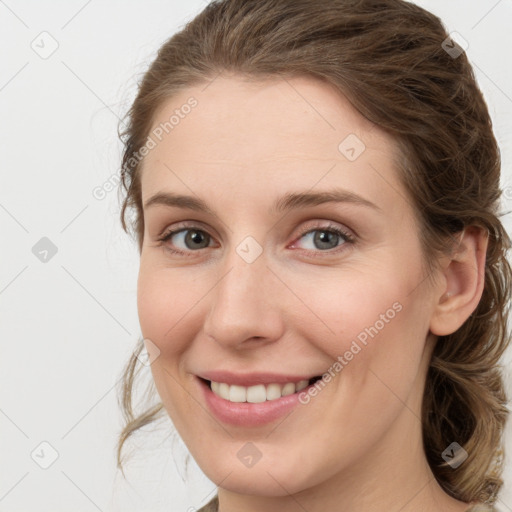 Joyful white young-adult female with medium  brown hair and green eyes