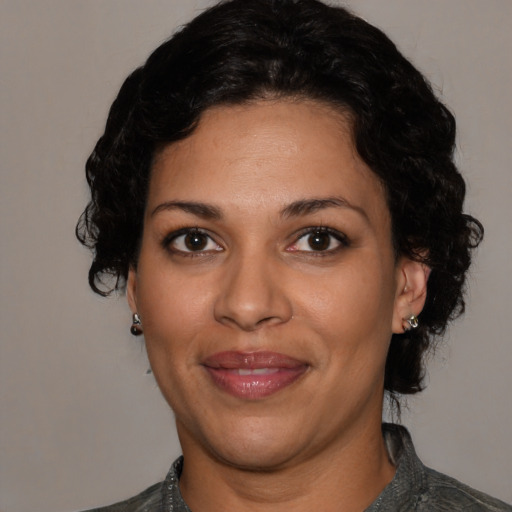 Joyful latino adult female with medium  black hair and brown eyes