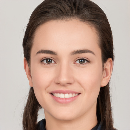 Joyful white young-adult female with long  brown hair and brown eyes