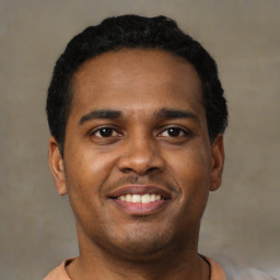 Joyful latino young-adult male with short  black hair and brown eyes