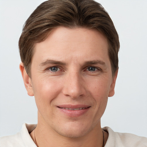 Joyful white young-adult male with short  brown hair and grey eyes