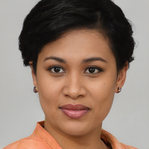Joyful latino young-adult female with short  black hair and brown eyes