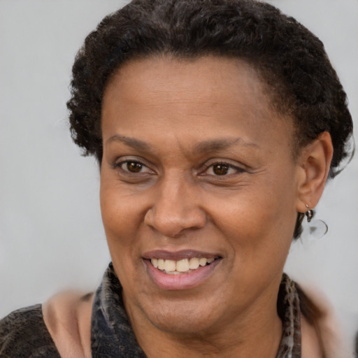 Joyful black adult female with short  brown hair and brown eyes
