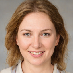 Joyful white young-adult female with medium  brown hair and blue eyes