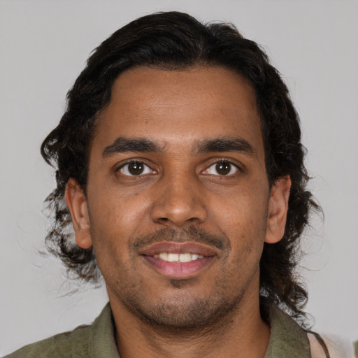 Joyful black young-adult male with short  brown hair and brown eyes