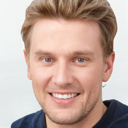 Joyful white young-adult male with short  brown hair and blue eyes