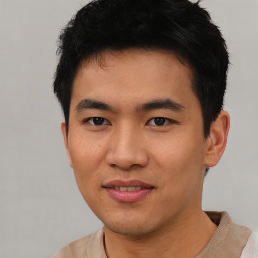 Joyful asian young-adult male with short  black hair and brown eyes