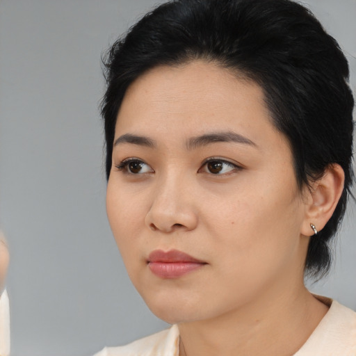 Joyful asian young-adult female with medium  black hair and brown eyes