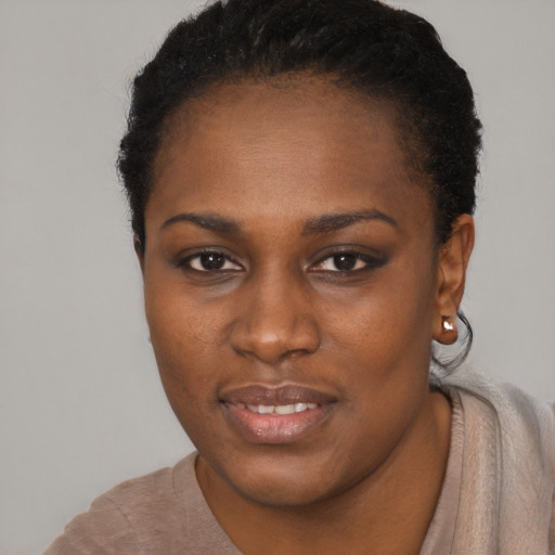 Joyful black young-adult female with short  black hair and brown eyes