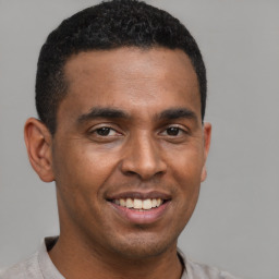 Joyful latino young-adult male with short  brown hair and brown eyes